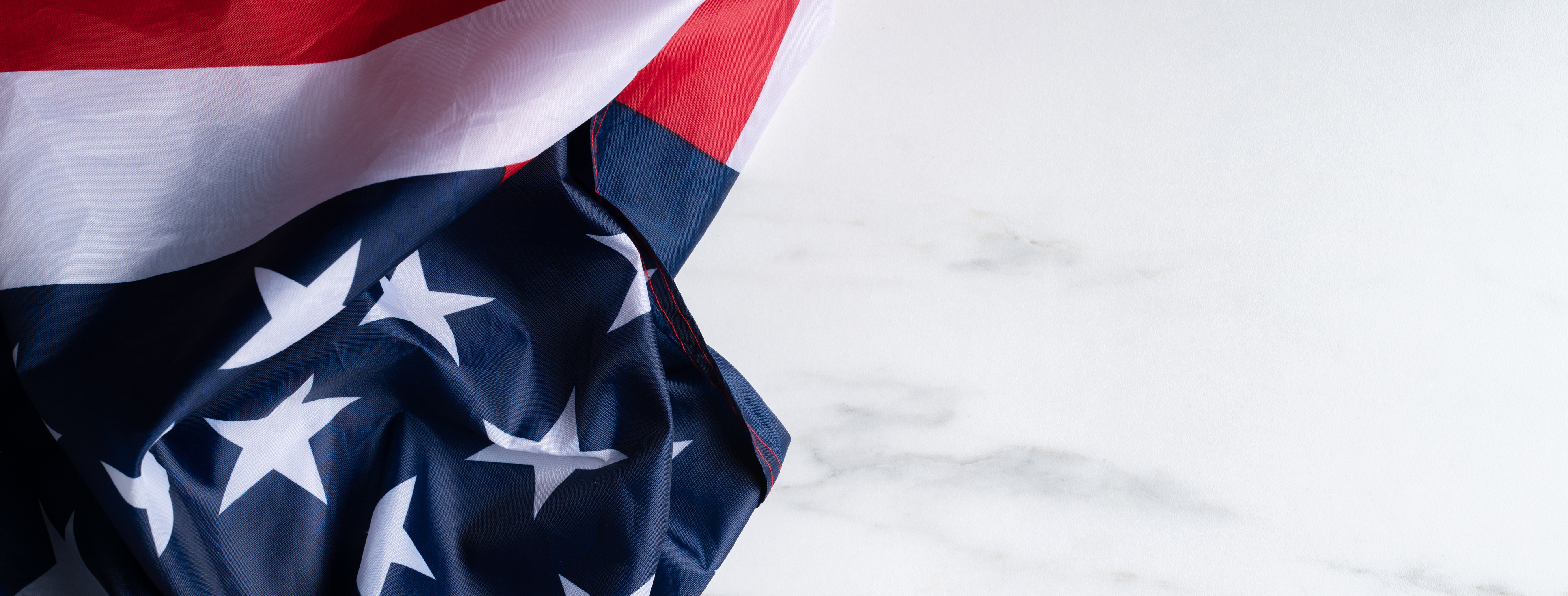 Concept of Independence day or Memorial day. Flag over bright marble table background.